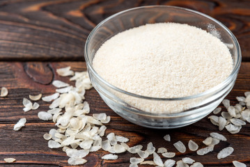 Rice flour on dark wooden background.