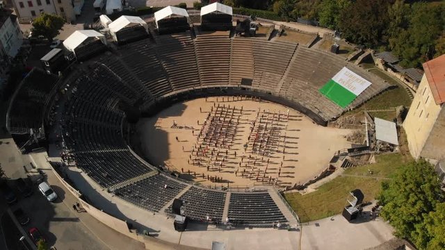 Aerial drone shot orbiting around the arena with musicians in Avenches Switzerland