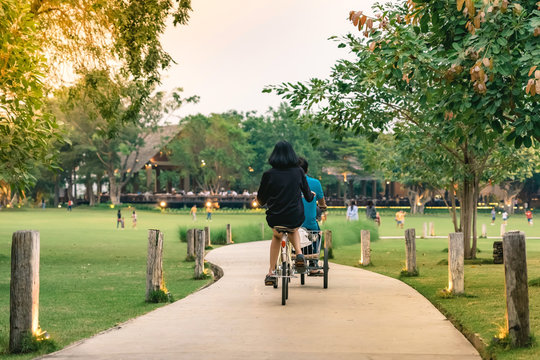 People exercising by cycling in the evening at the public park.
