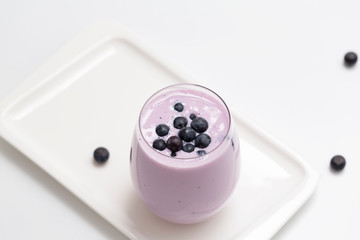 Blueberry smoothie with fresh blueberries on light background. Healthy summer drink. Vegetarian dessert. Selective focus. 