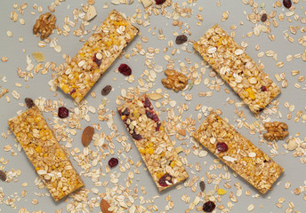 Granola bar. Cereal granola bar with nuts, fruit and berries on a gray stone table. Healthy sweet dessert snack. Vegan food. Top view. 