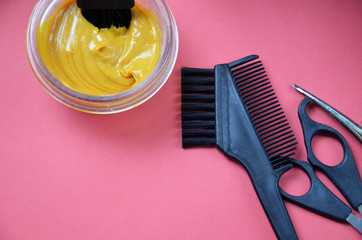 Barber shop set with hair dye, hairbrush, scissors, spray and brush on pink red background