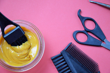Barber shop set with hair dye, hairbrush, scissors, spray and brush on pink red background
