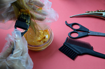 Barber shop set with hair dye, hairbrush, scissors, spray and brush on pink red background