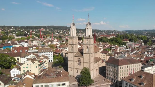 Aerial drone shot circling around and flying towards Grossm&uuml;nster church in Z&uuml;rich Switzerland
