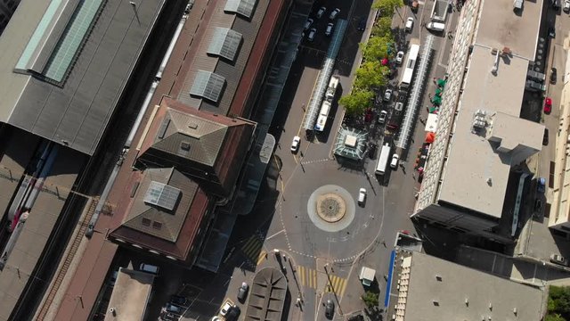 Aerial drone shot tilting up while circling above Lausanne CFF train station revealing the train station and lake Geneva in the background