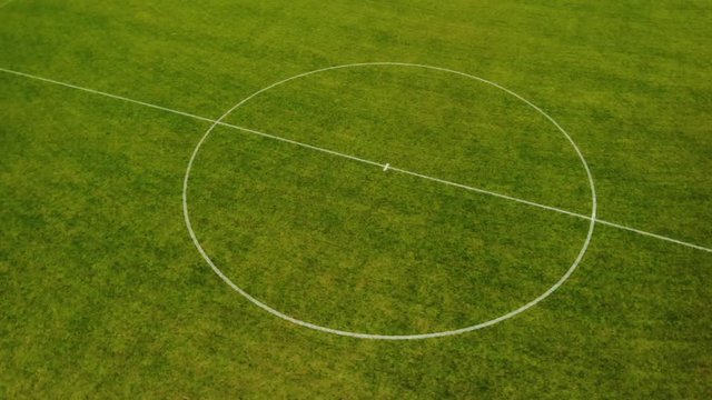 Aerial drone shot circling around center circle of football field short