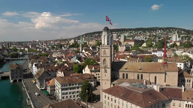 Aerial drone wide cinematic shot circling around Grossm&uuml;nster church in Z&uuml;rich Switzerland