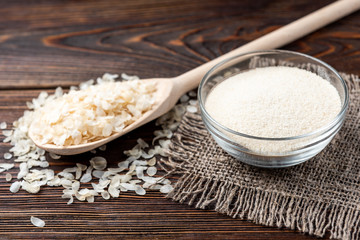Rice on dark wooden background.