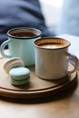 cup of coffee and tea and macarons on wooden desk