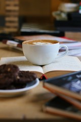 cup of coffee and cookies on book