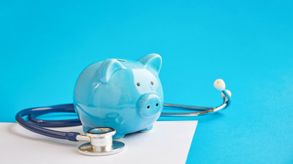 Piggy bank with stethoscope isolated on blue background. concept of financial literacy. Creating...