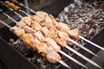 Georgian shish kebab. Meat on the coals. Brazier with fire. Folk cuisine. Meat on skewers. Coal and smoke.