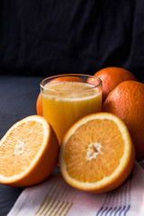 Fresh orange juice and fresh fruit oranges on a black background