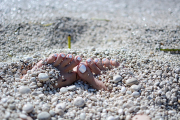 feet in pebbles on the beach