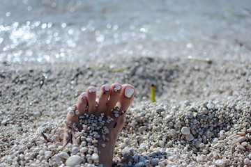 feet in pebbles on the beach