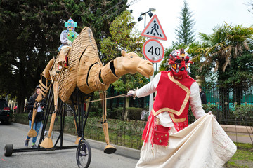 Sochi, Russia - 10 MAR 2019. Street theater actor walking down the street. Scenery in the form of a camel on wheels, he leads. Street theatre festival in Sochi