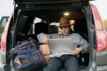 young boy watching series on the laptop in the car during travel vacation