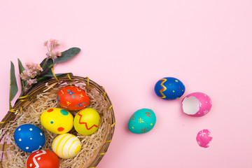 easter eggs in basket on pink background