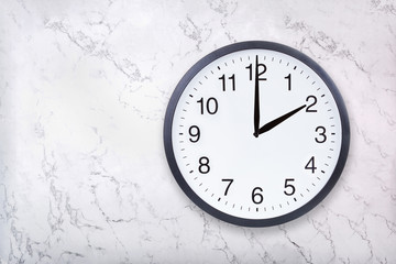 Wall clock show two o'clock on white marble texture. Office clock show 2pm or 2am on marble background