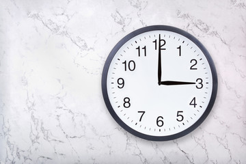 Wall clock show three o'clock on white marble texture. Office clock show 3pm or 3am on marble background