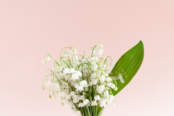 Bouquet of lilies of the valley with green leaves