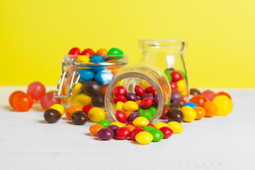 Bottles with sweet candies on table