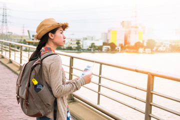 Asian girl tourist backpack Thinking of a place Have a map to find places to visit. See directions to go next in the holiday.