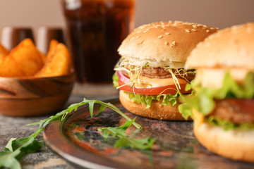 Plate with tasty burgers on table, closeup