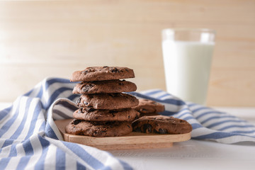 Board with tasty chocolate chip cookies on table