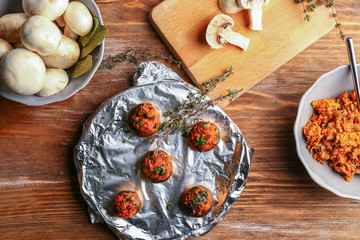 Plate with tasty stuffed mushrooms on wooden table