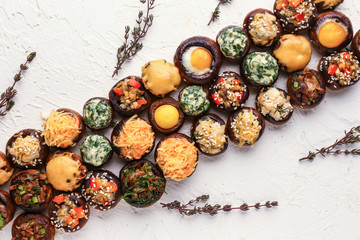 Tasty stuffed mushrooms on white textured background