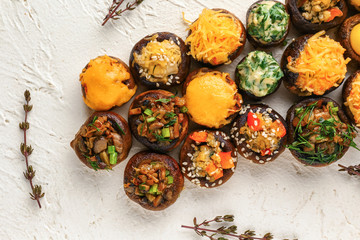 Tasty stuffed mushrooms on white textured background