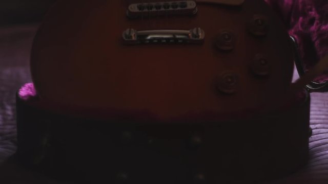 Man pulling out a guitar out of case. Closeup