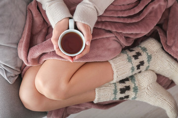 Young woman drinking hot tea at home