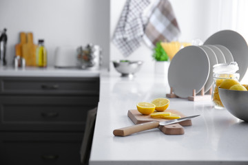Fresh lemon with cutting board on table in kitchen