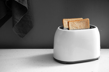 Toaster with bread slices on kitchen table