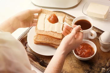 Woman eating tasty toasts with jam for breakfast
