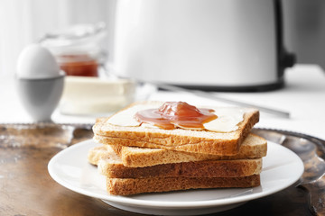 Tasty toasts with butter and jam on plate