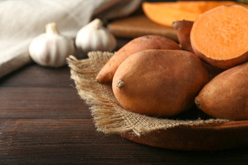 Raw sweet potato on wooden table