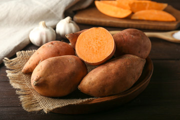 Raw sweet potato on wooden table