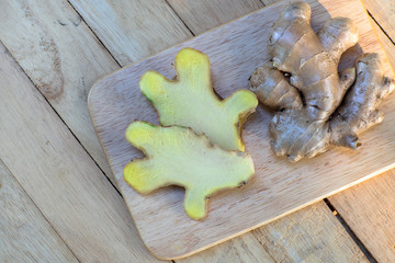 Fresh ginger on wooden chopping board, herb ingredient concept