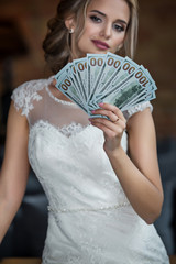 A bride holds dollars fan in loft interior room