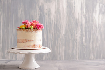 Sweet cake with floral decor on grey background