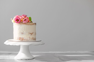 Sweet cake with floral decor on grey background