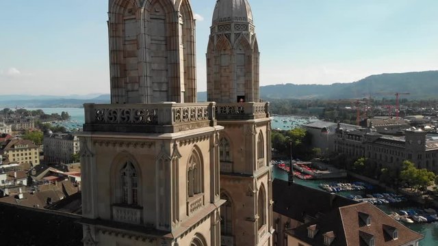 Cinematic aerial drone shot flying away from and circling around Grossm&uuml;nster church in Z&uuml;rich Switzerland