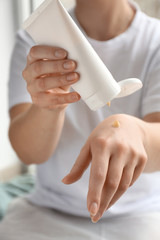 Young woman applying hand cream, closeup