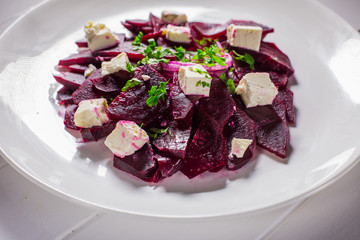 Vitamin salad with beets and Feta cheese in a white plate