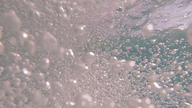 POV shot of jumping into blue, tropical water and then bobbing up to the surface and back under