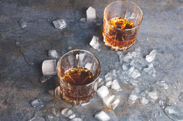 An alcohol drink and ice. Whisky with pieces of ice.Glasses with a strong beverage